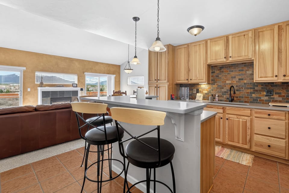 Cook and gather in your spacious kitchen featuring beautiful wood cabinetry, granite counters, and a welcoming breakfast bar perfect for morning coffee.