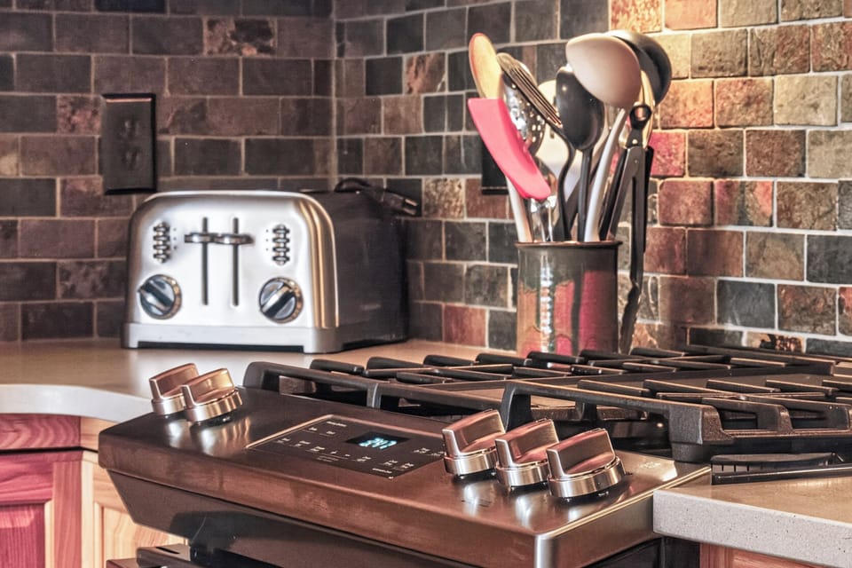 Your culinary adventures await in this beautifully appointed kitchen, featuring gleaming copper-finish appliances and all the tools you need.