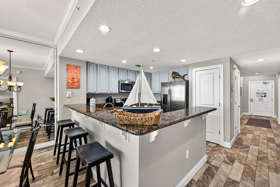 Gather around the spacious kitchen island with granite countertops, modern appliances, and coastal charm.