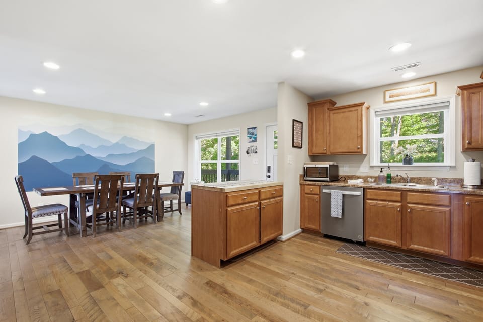 Bright open kitchen & dining space with mountain mural and natural light