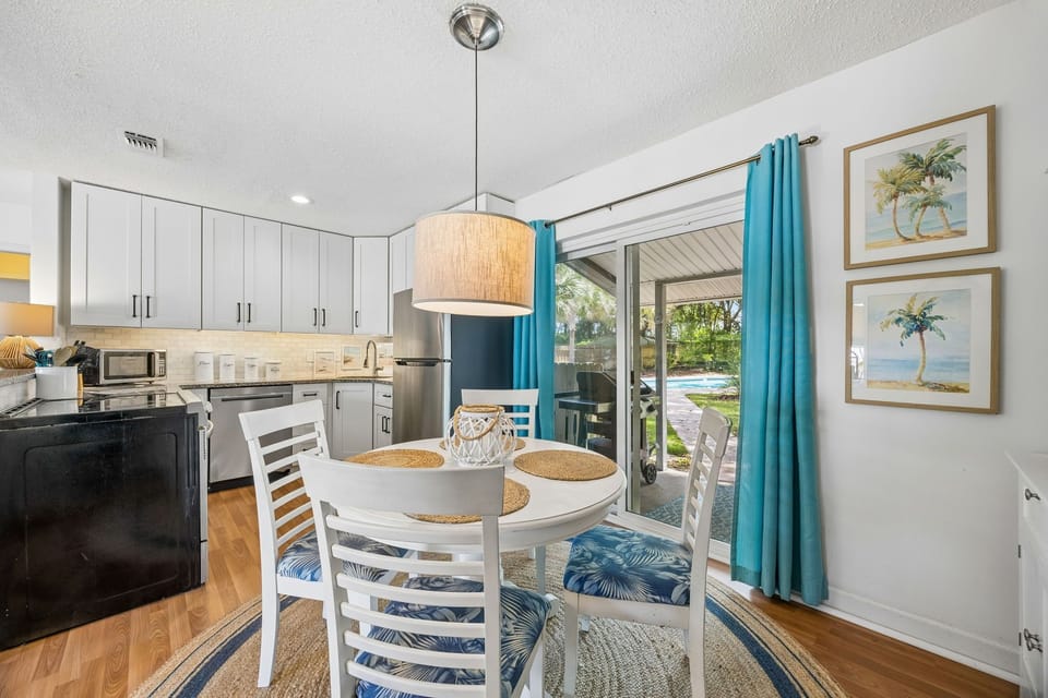 Enjoy your morning coffee at this bright dining table, where tropical breezes and poolside views invite you to unwind and savor every moment of your stay.