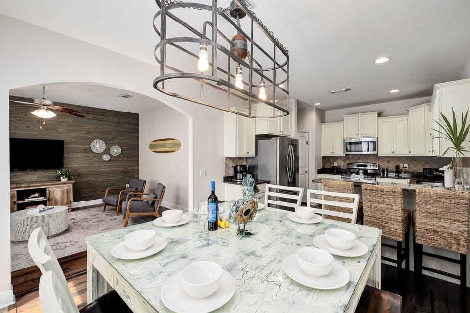 Picture yourself gathering around this elegant dining table with seating for eight, flowing seamlessly into a fully equipped kitchen and cozy living area—perfect for unforgettable meals and relaxed evenings together.