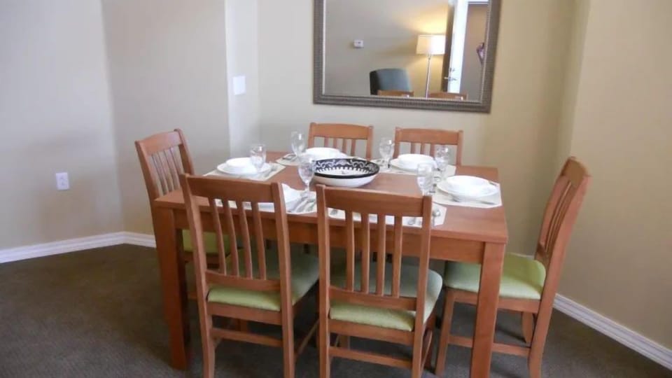Dining table set for six with elegant dinnerware.
