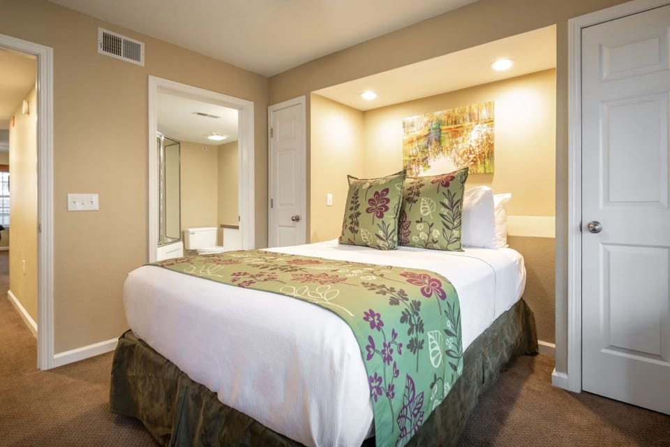 Second bedroom featuring a queen bed and warm decor.