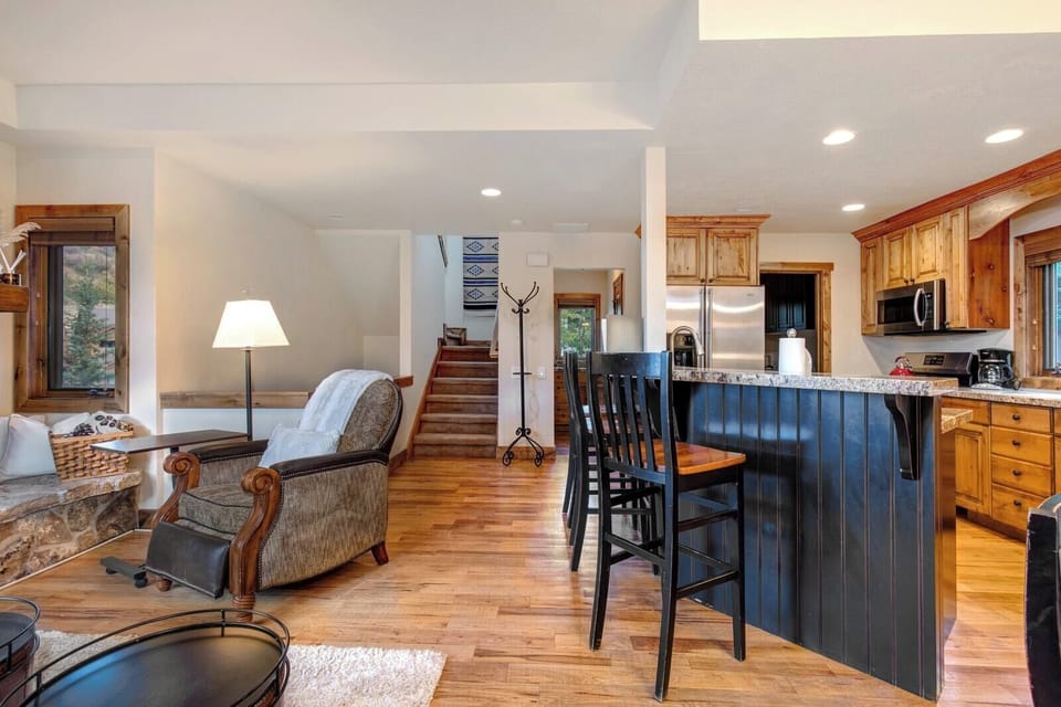 The fully equipped kitchen features granite counters, bar seating, and full-size appliances.