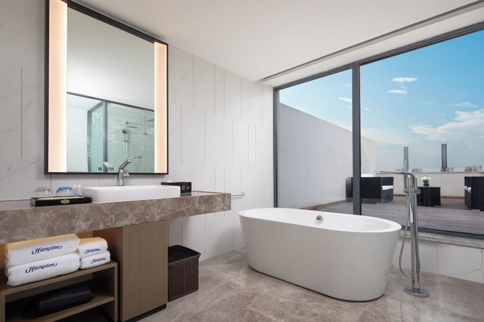 Business Suite | Bathroom | Hair dryer, slippers, towels, soap