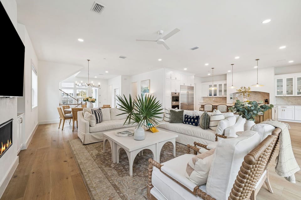 Your stylish open-concept living space awaits with plush seating, modern kitchen, and warm coastal touches throughout.