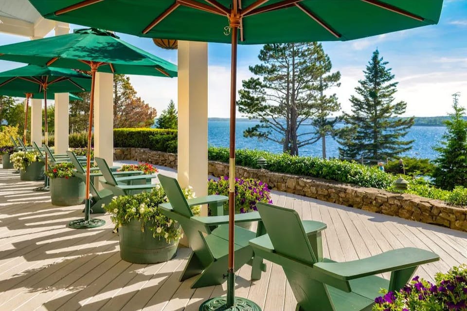 Sip something cool beneath shady umbrellas while gazing out across calm waters and towering pines.
