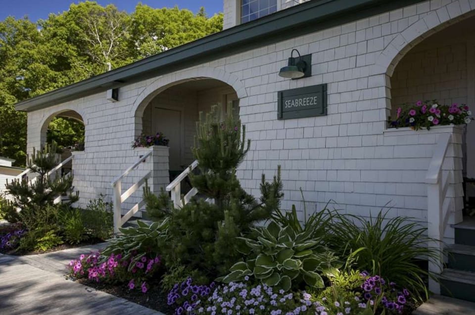 Lush gardens and storybook arches create a warm welcome at this coastal cottage retreat.