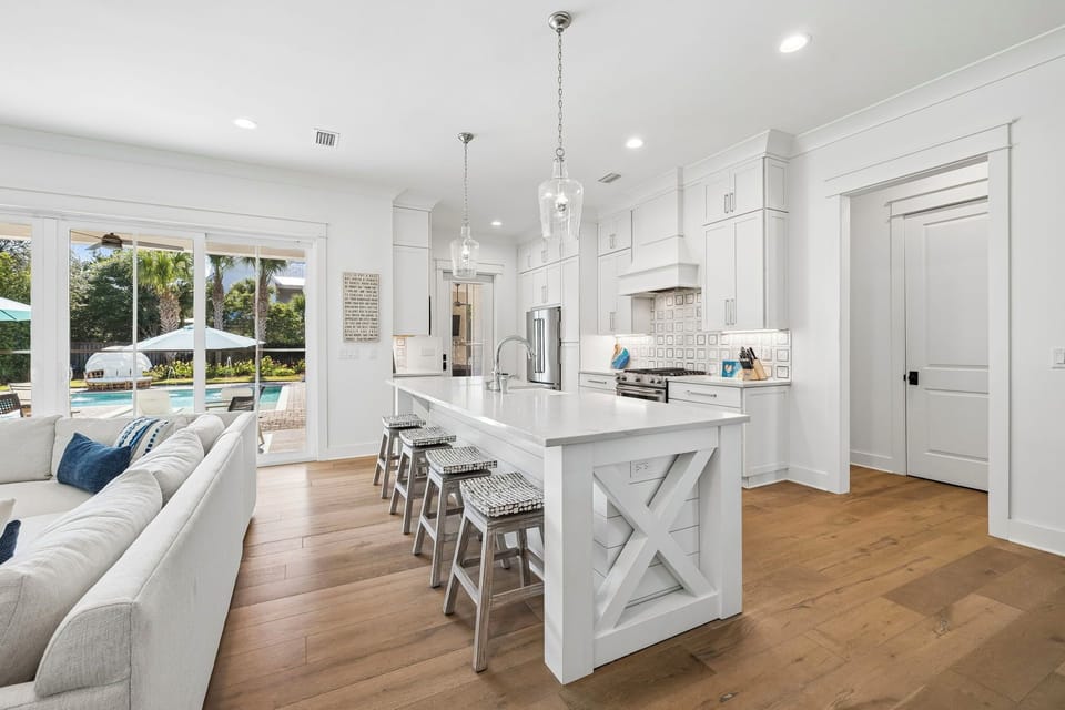 Gather around this bright kitchen island while sunlight pours through glass doors revealing your private pool. Everything you need to cook and create vacation memories together.