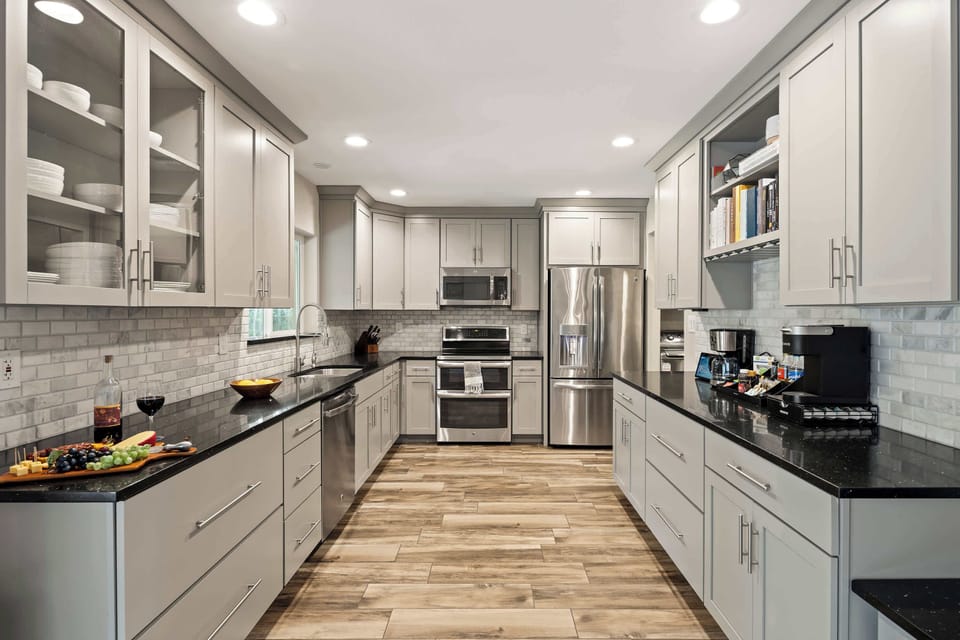 Fully equipped kitchen with stainless steal appliances, ample counter space, and a large pantry with a mini fridge and wine cooler.