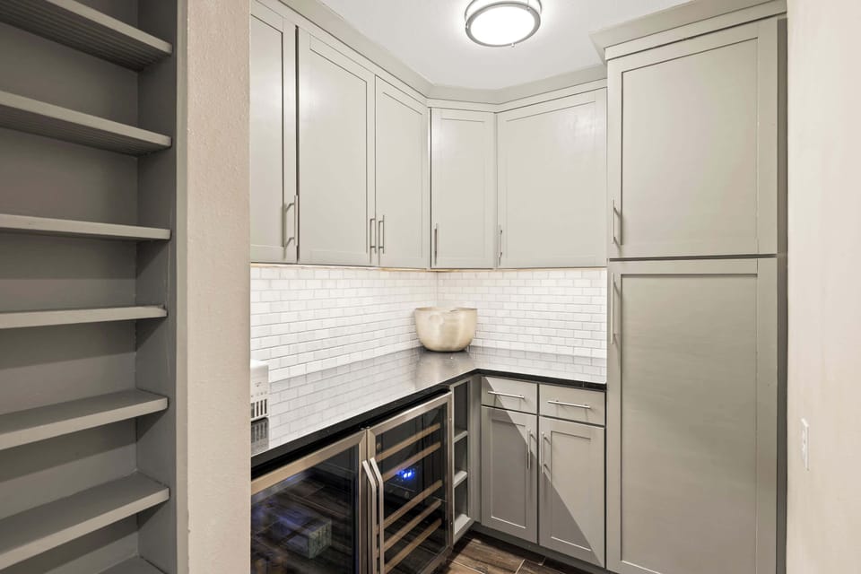 Fully equipped kitchen with stainless steal appliances, ample counter space, and a large pantry with a mini fridge and wine cooler.