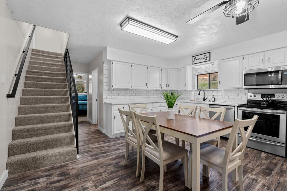 Kitchen | Dining Table & White Cabinetry | Open Staircase Layout