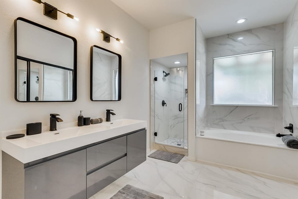 A bright, modern bathroom with a spacious shower and soaking tub—perfect for freshening up and enjoying a relaxing, spa-like experience.

