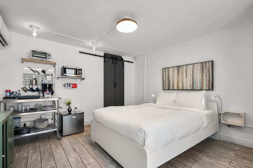 Wake up refreshed in a pristine double bed. Features stylish matte-black barn doors and minimalist design perfect for couples and digital nomads.