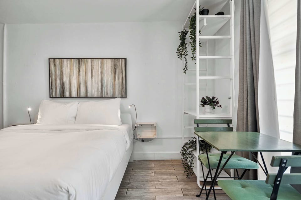 A sunlit workspace right by the window with refreshing green accents. The ultimate setup for a productive remote work morning or breakfast for two.