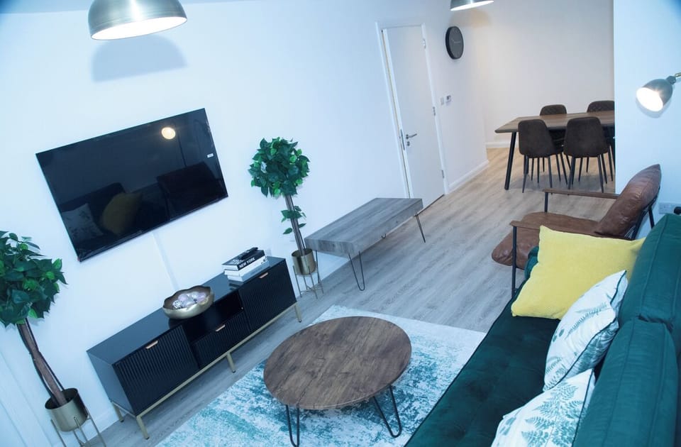 Bright living room with extra chair, television, wifi, heating and a balcony view.