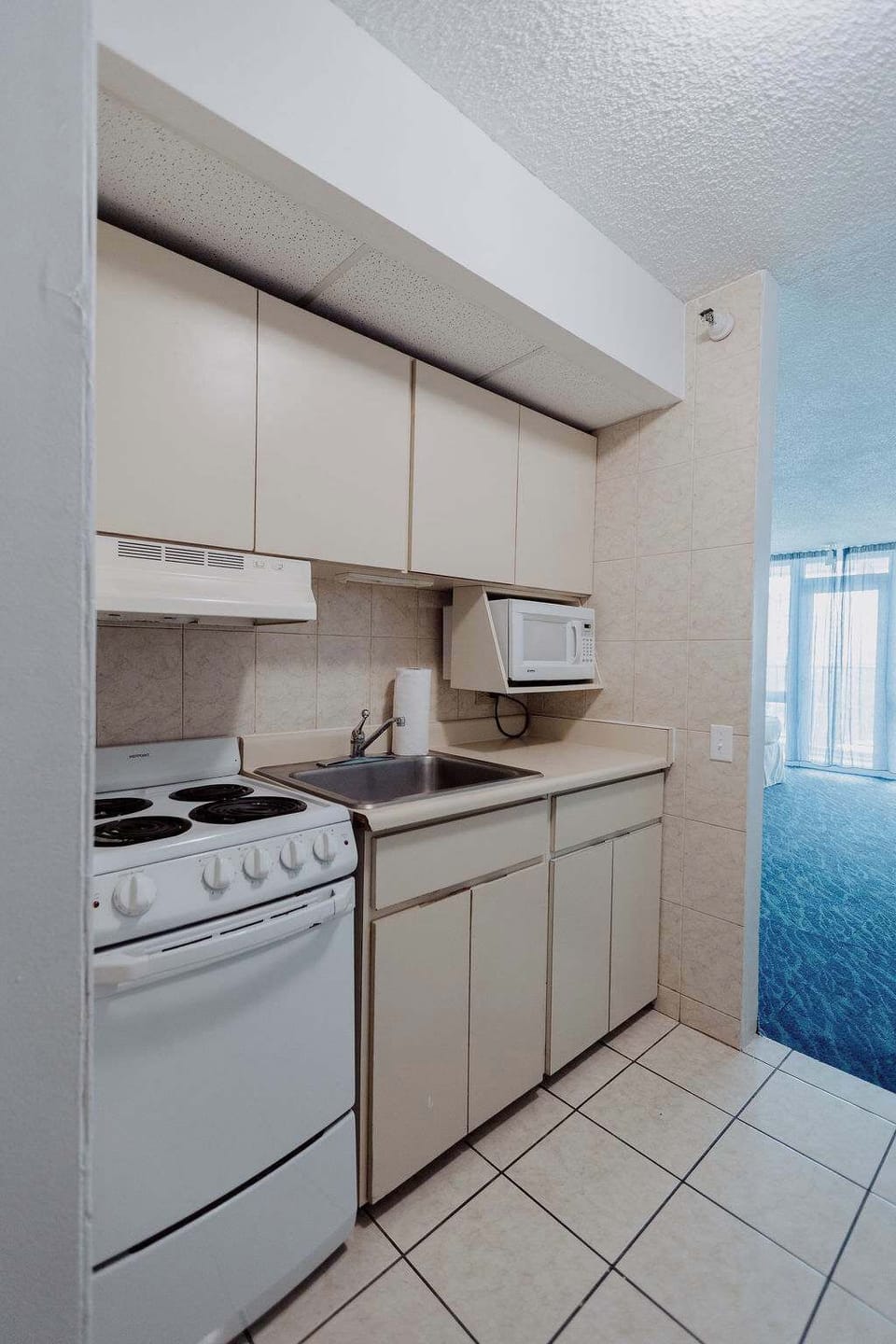 Fully equipped Isla Verde kitchenette with stove, oven, microwave, sink, and storage cabinets for easy vacation cooking.