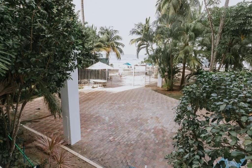 Private gated walkway framed by lush tropical gardens leading directly onto Isla Verde Beach, offering effortless beachfront access with ocean views and plenty of shade for a relaxing Caribbean escape.