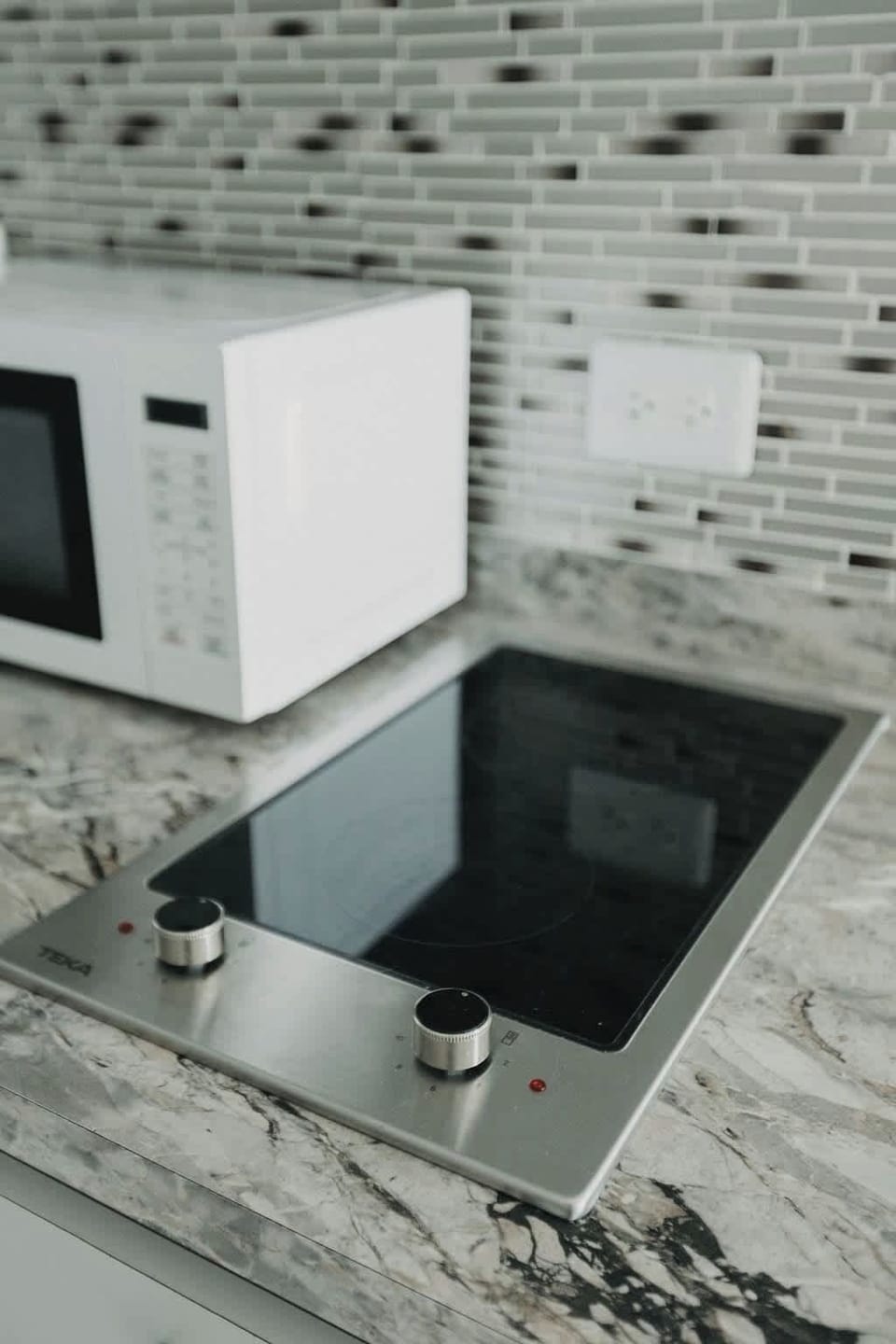 Modern two‑burner electric cooktop lets you sauté, boil, and pan‑sear simple meals at home between beach days and nights out.
