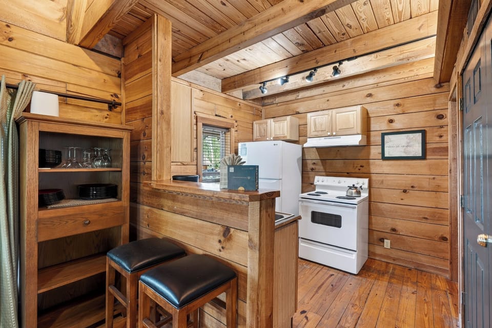 A charming, cabin-style kitchen with rustic wood finishes and a breakfast bar—perfect for easy mornings and casual meals. (Elijah's Cabin)