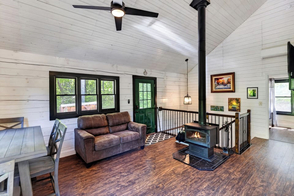 Welcome to your cozy mountain retreat, featuring an open-concept living area with a warm wood-burning stove.