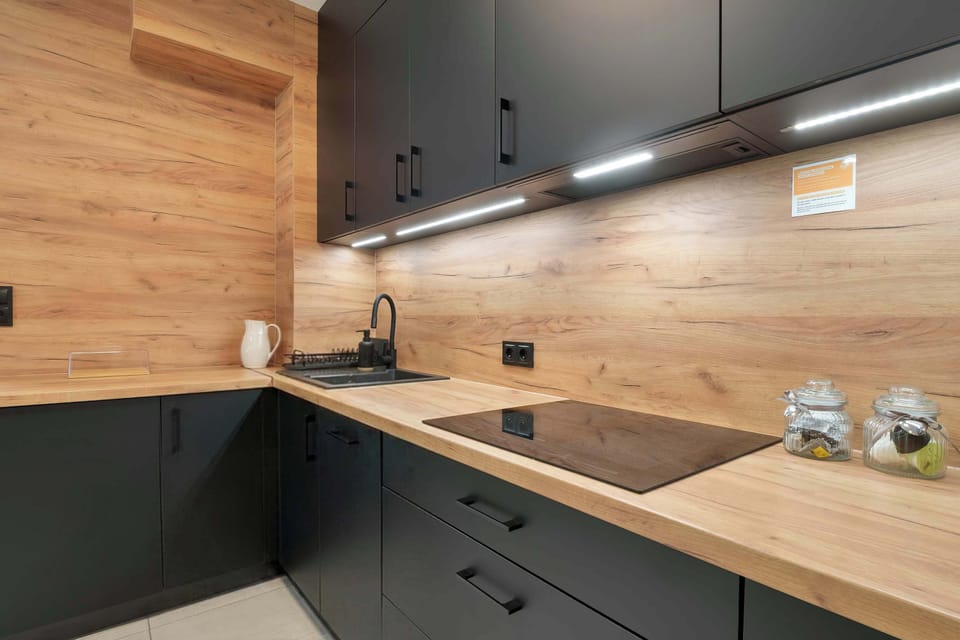 A close-up of a sleek kitchen counter with under-cabinet lighting and modern appliances.