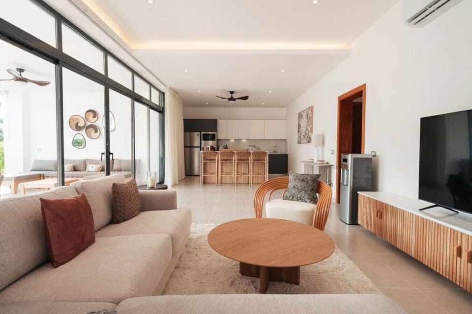 Spacious living room with a comfy sofa, TV, and a fully equipped kitchen just steps away.