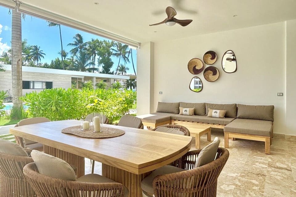 Spacious covered patio with outdoor dining and lounge seating, ideal for meals, morning coffee, or relaxing by the pool area.