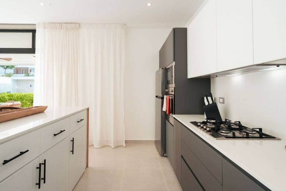 Fully equipped kitchen with a gas stove, microwave, refrigerator, and plenty of counter space.