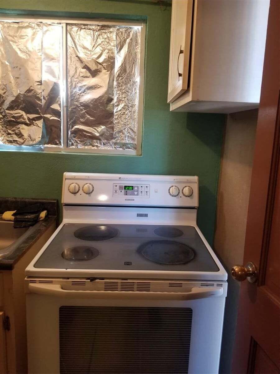 The well-equipped kitchenette includes a gas cooker for meal preparation, along with a microwave, refrigerator, coffee maker, and essential cookware.