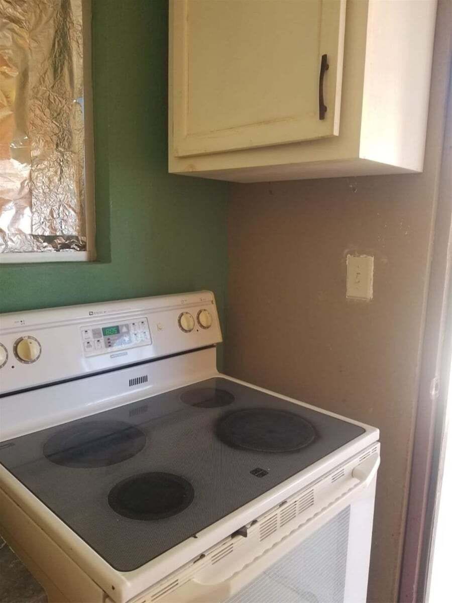The well-equipped kitchenette includes a gas cooker for meal preparation, along with a microwave, refrigerator, coffee maker, and essential cookware.