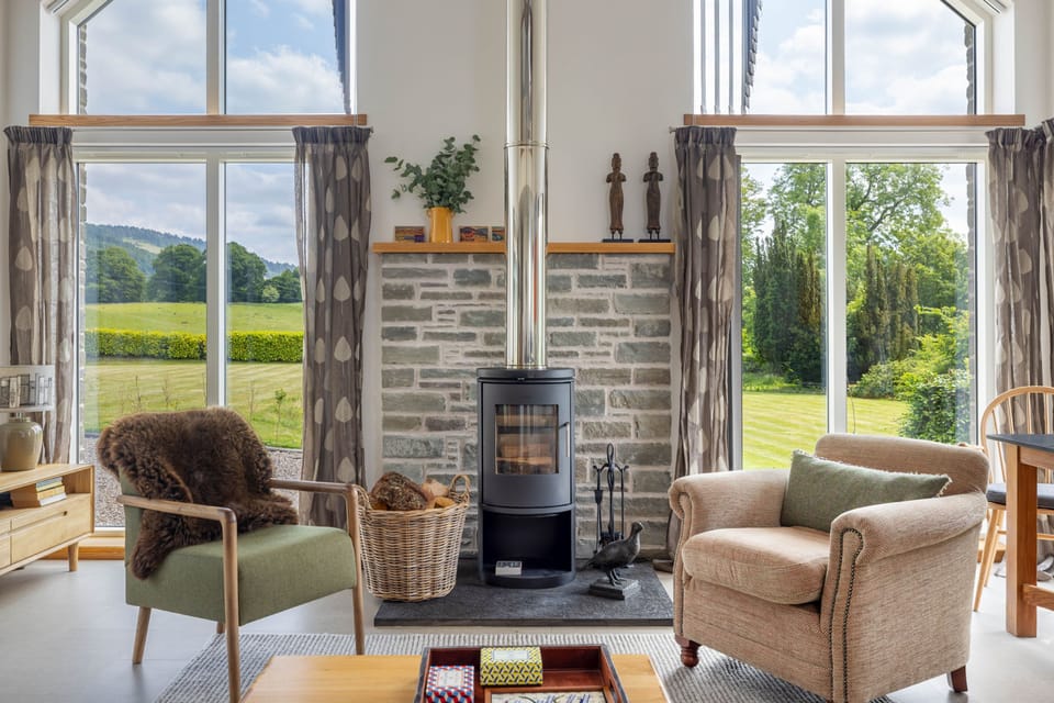 Flooded with natural light and framed by panoramic rural views, this welcoming living area is perfect for relaxing in every season