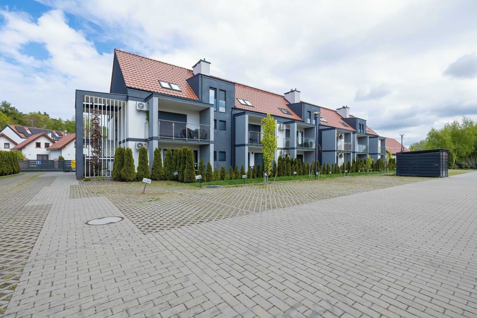 Modern apartment building located in a peaceful residential area with convenient access and parking nearby.