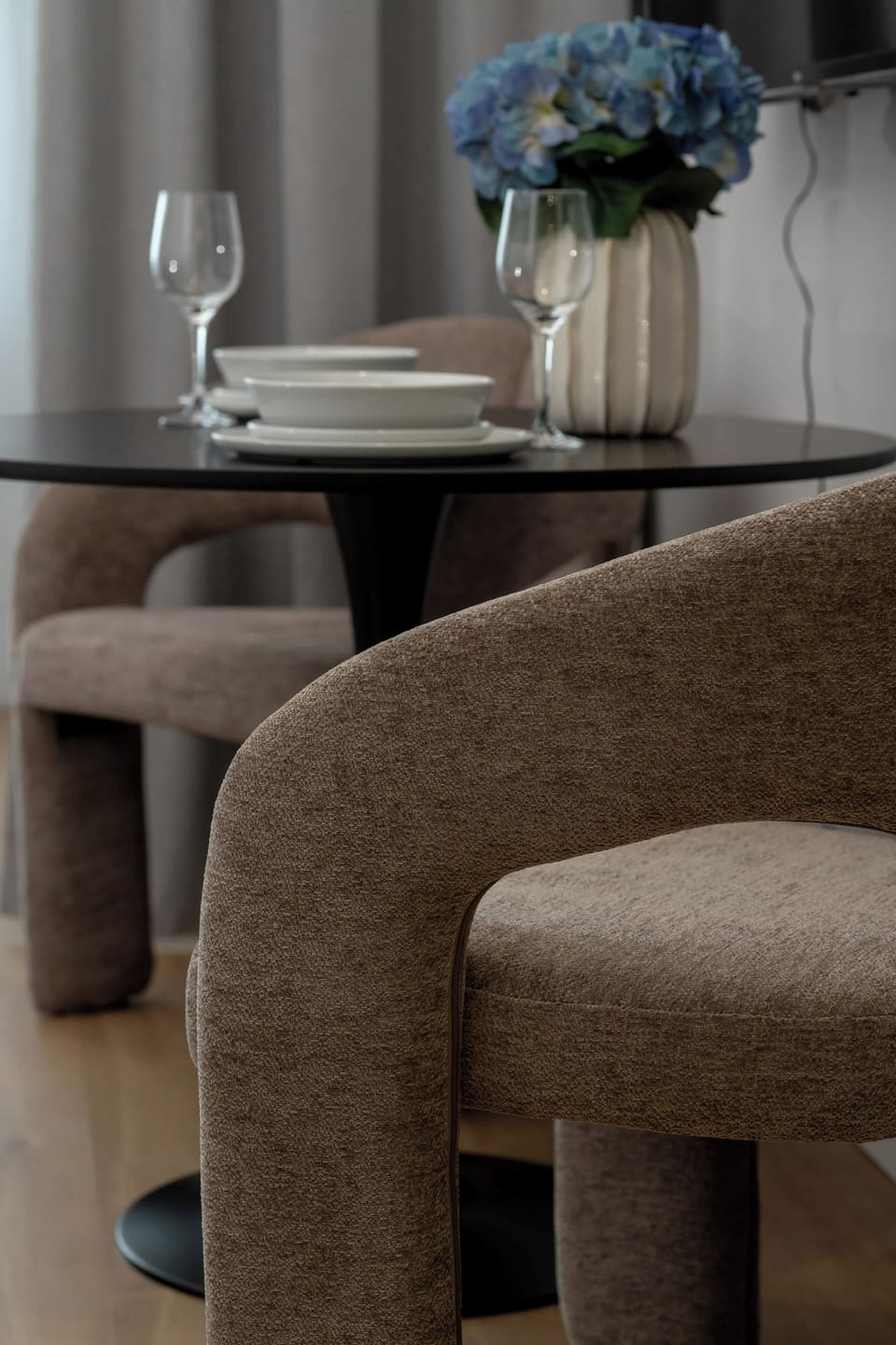A stylish dining area detail with modern chairs and decorative accents. The elegant setup creates a pleasant atmosphere for shared meals and coffee breaks.