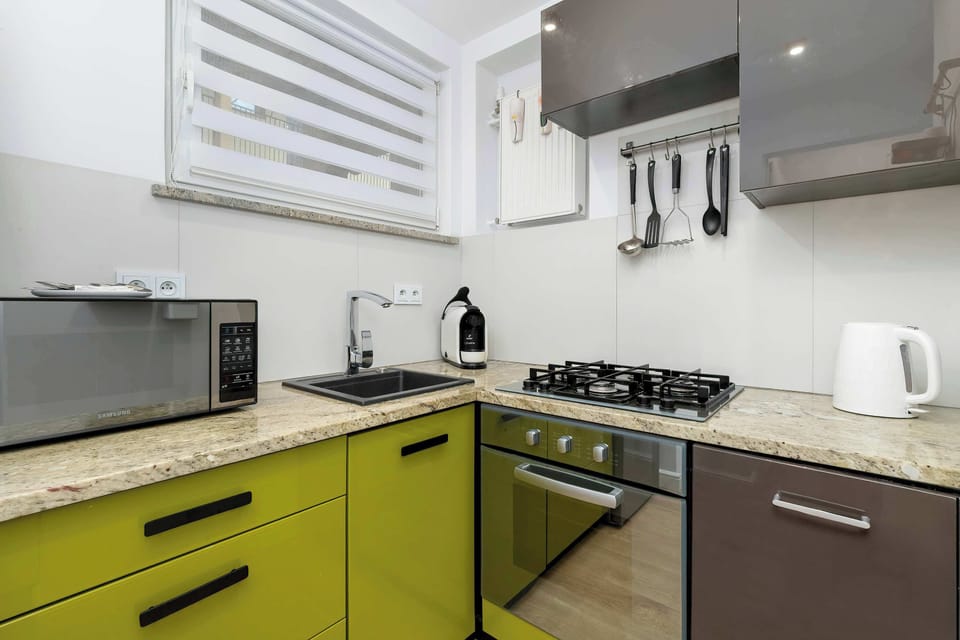 A fully equipped kitchen with colorful cabinets, a gas stove, and essential appliances. The functional layout makes preparing homemade meals easy and convenient.