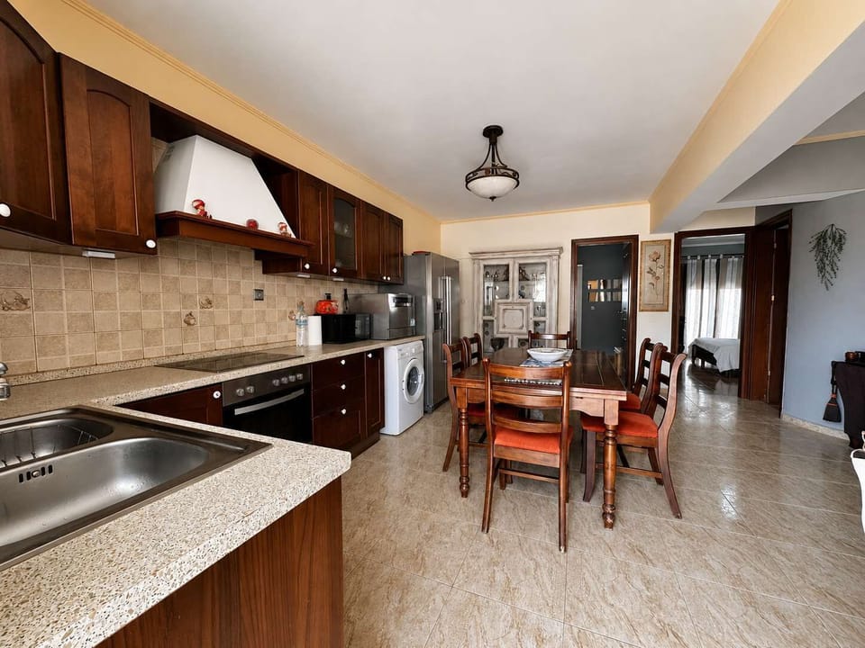 Fully equipped kitchen with spacious dining table and modern appliances