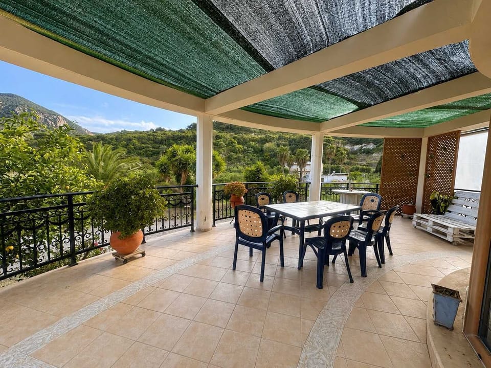 Expansive shaded veranda perfect for outdoor dining and relaxation