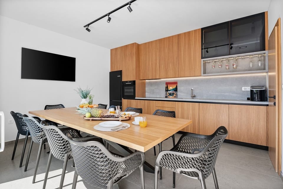 The fully equipped summer kitchen features a fridge, ice maker, and dining table for 8.