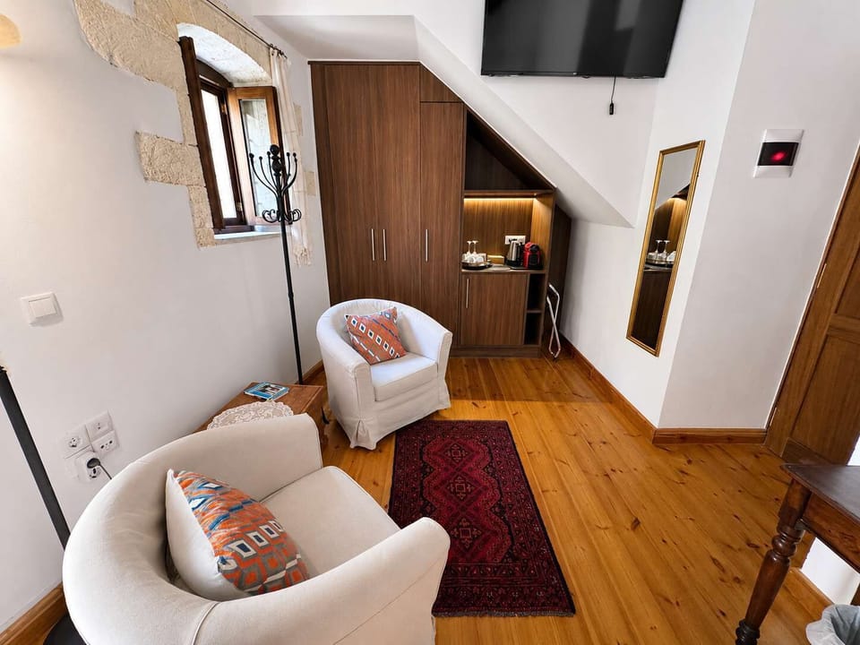 Bright bedroom with a comfortable bed, exposed wooden beams, and wooden furnishings, creating a warm and authentic atmosphere.