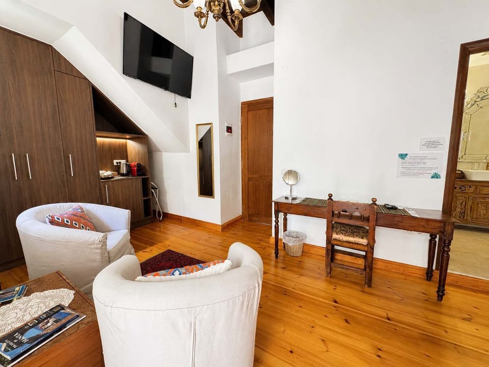 Bright bedroom with a comfortable bed, exposed wooden beams, and wooden furnishings, creating a warm and authentic atmosphere.