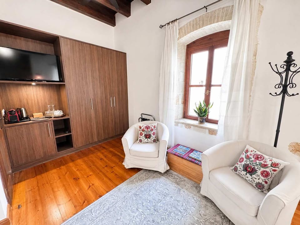 Bright bedroom with a comfortable bed, exposed wooden beams, and wooden furnishings, creating a warm and authentic atmosphere