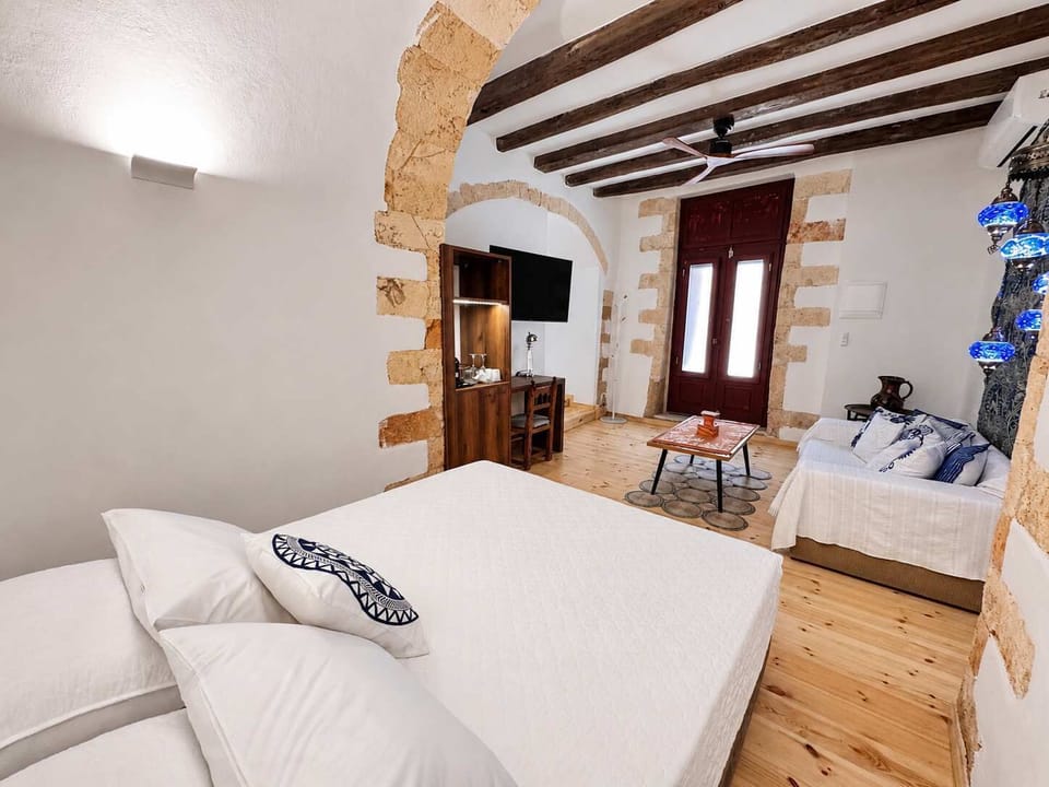 Bright bedroom with a comfortable bed, exposed wooden beams, and wooden furnishings, creating a warm and authentic atmosphere.