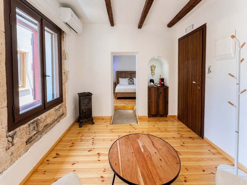 Small lounge area within the bedroom featuring comfortable armchairs and a coffee table, perfect for relaxing, reading, or enjoying a quiet moment in a warm and elegant setting
