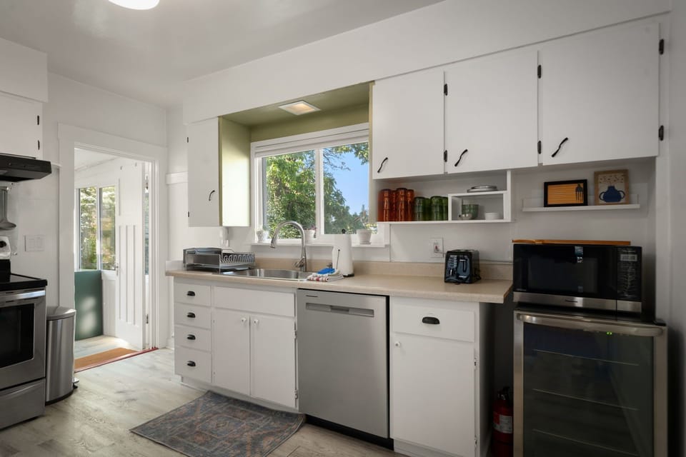 Prepare easy meals in the fully equipped kitchen with modern appliances and sunlight.