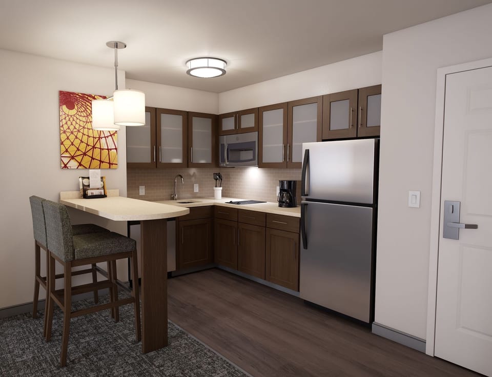 The kitchen area is equipped with modern appliances, including a refrigerator, microwave, and ample cabinetry.