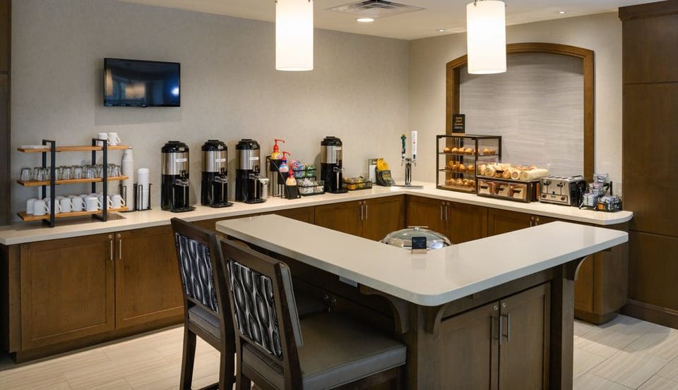The breakfast bar showcases a variety of coffee options and pastries, creating a welcoming start to the day for guests.