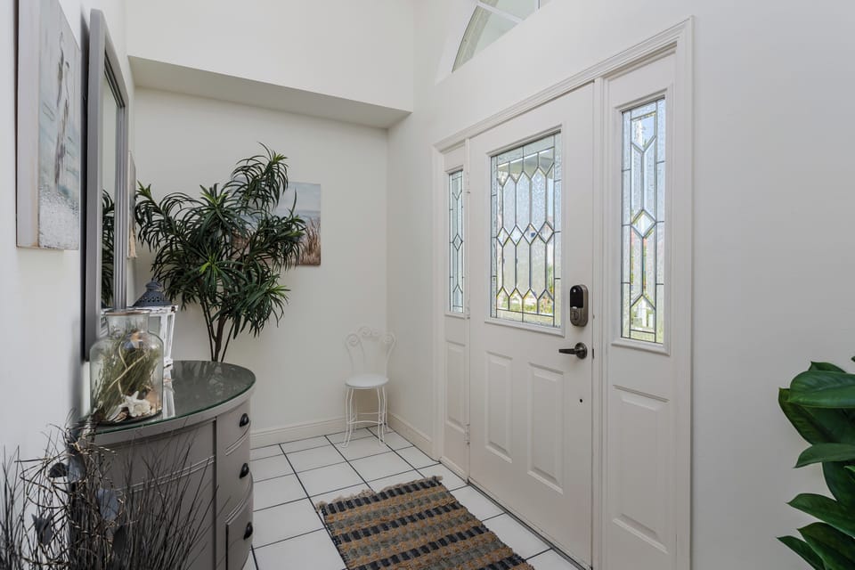 Bright entrance with skylights, elegant stained glass door, and welcoming tile floors greet arriving guests.
