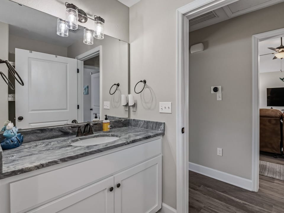 Master bathroom with double vanity, granite countertop, and large mirror