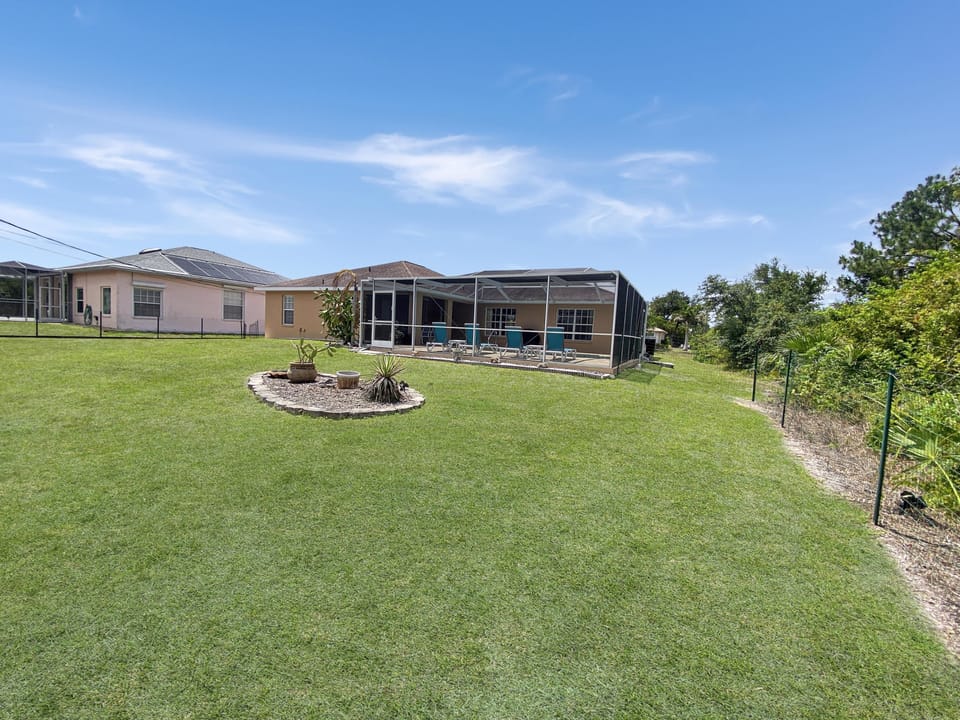 Expansive backyard with screened patio, perfect for outdoor relaxation and gatherings.
